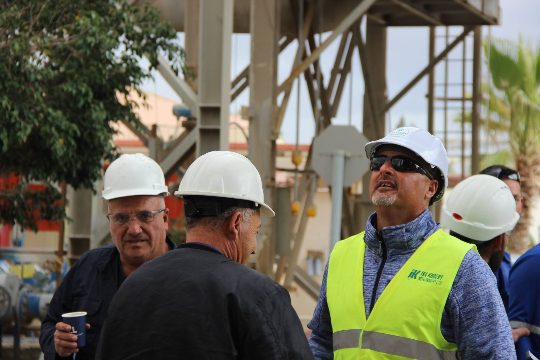 Engineers reviewing plans in front of an industrial plant